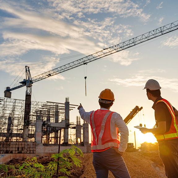 Asian two business man construction engineers supervising progress of construction project at construction site.